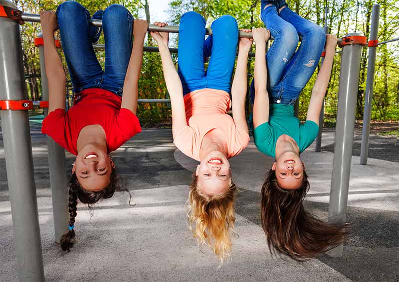 gilrs on playground upside down